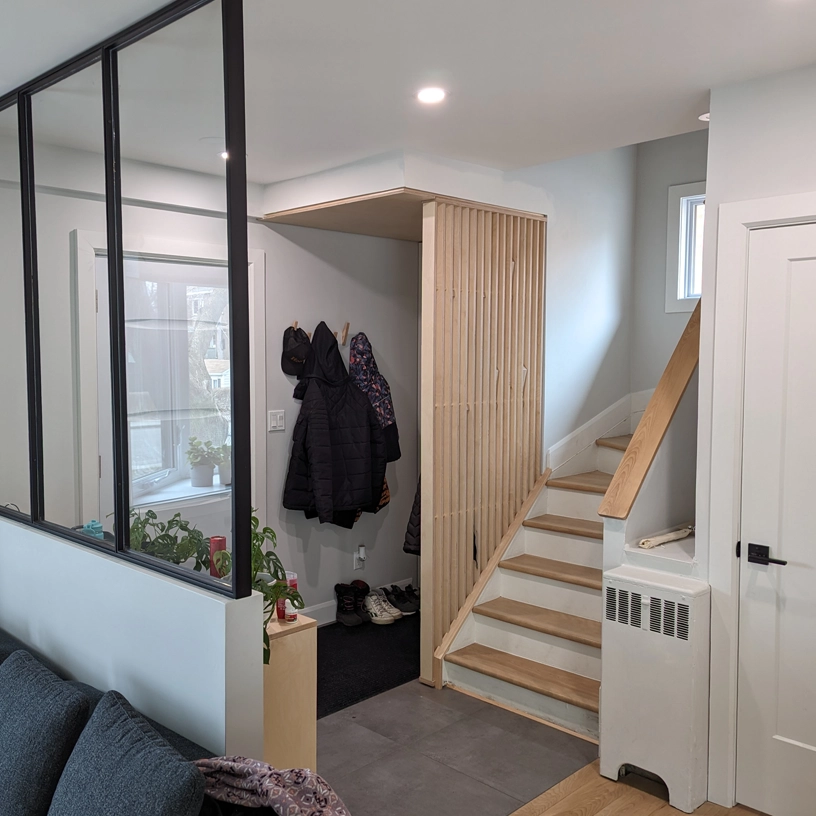 Entrée rénovée avec escalier moderne en bois et cloison en bois