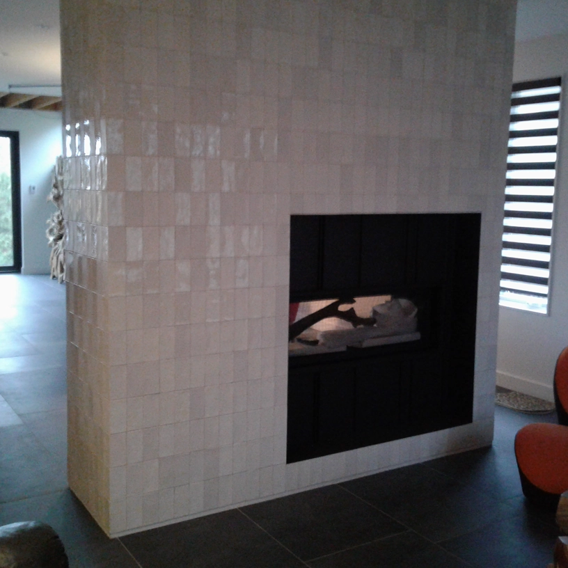 Mur en céramique avec foyer encastré dans un salon rénové